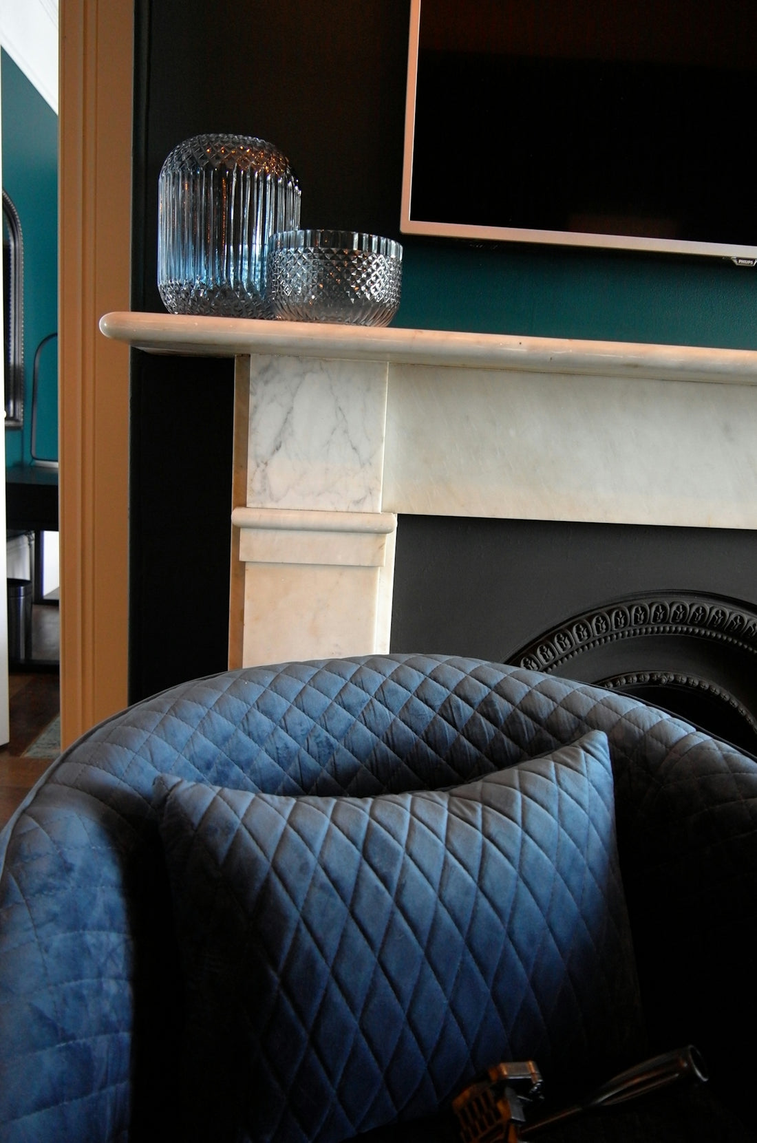 a blue couch in front of a fireplace