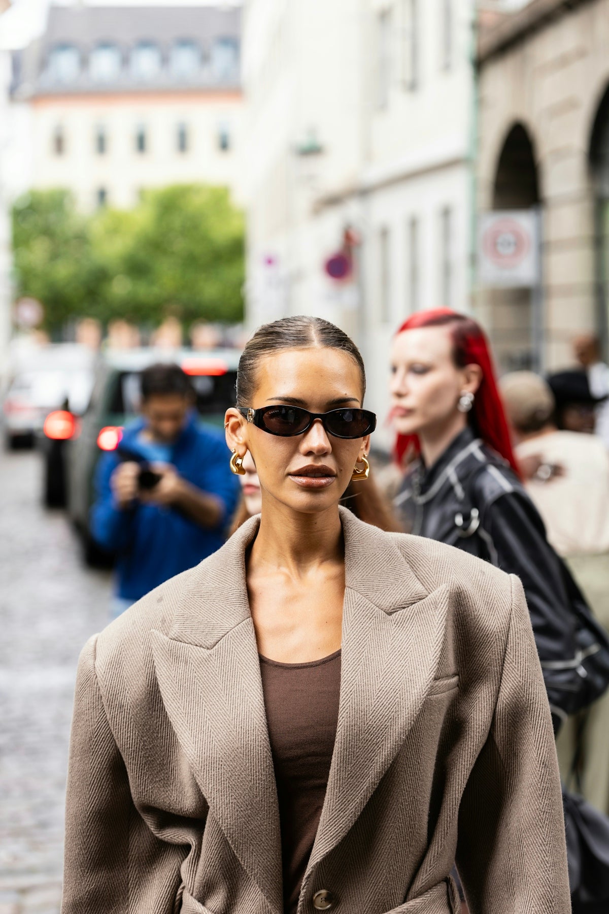 Woman in oversized coat and sunglasses on street